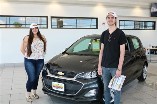 Two students with a car they won 